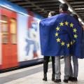 Jugendliche mit EU-Flagge auf Bahnsteig