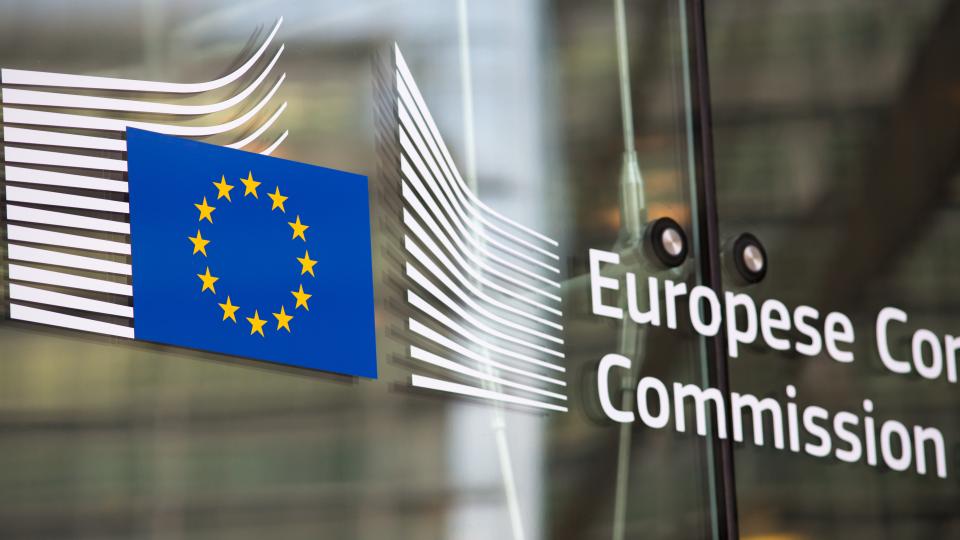 EU-Sterne und Logo EU-Kommission auf Glastür