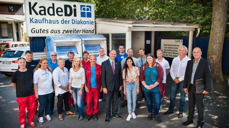 Foto: Gruppenbild mit NRW-Arbeitsminister Rainer Schmeltzer und Mitarbeiterinnen und Mitarbeitern der Kaufhäuser der Diakonie