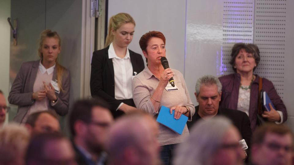 Foto: Eine Frau stellt Fragen ans Publikum