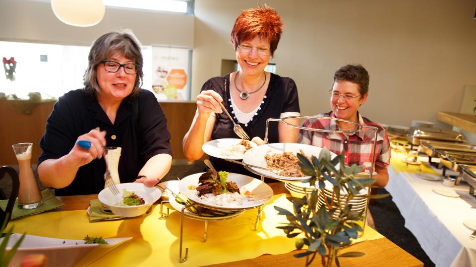 Foto: Drei Frauen bei Essensausgabe