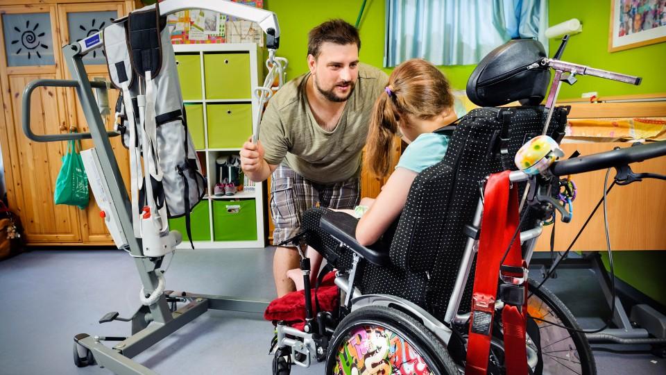 Ein Mann unterhält sich mit einer jungen Frau im Rollstuhl