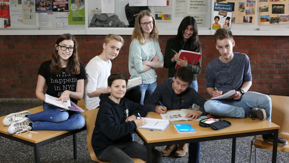 Gruppenfoto mit 7 SchülerInnen gruppiert um Schultisch