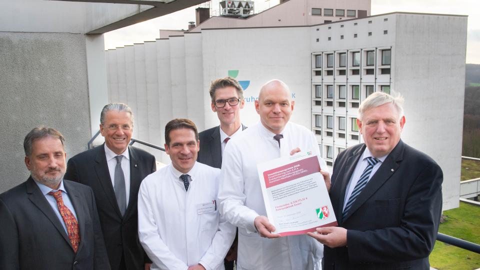 Minister Laumann übergibt einen symbolischen Förderbescheid an  den Geschäftsführer der Ruhrlandklinik und Kaufmännischer Vorstand des Universitätsklinikum Essen, Thorsten Kaatze, und weiteren Beschäftigten der Klinik.