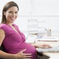 Eine schwangere Frau sitzt an einem Laptop