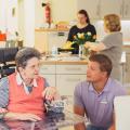 Foto zeigt ältere Dame mit Pfleger im Pflegeheim